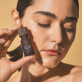 LYPHAZENT™ Lolûm – femme tenant le flacon d'huile drainante près de son visage