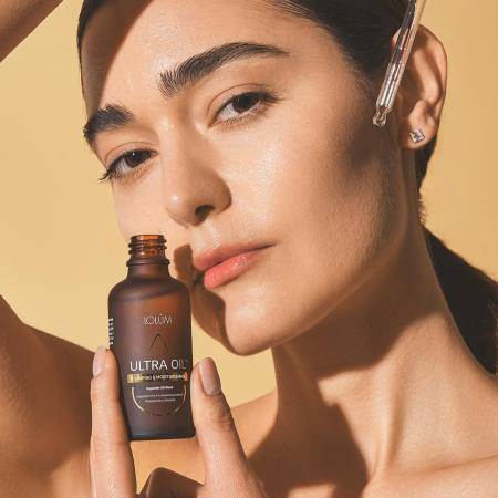 ULTRA OIL™ Lolûm – femme tenant le flacon compte-gouttes d'huile repulpante et hydratante